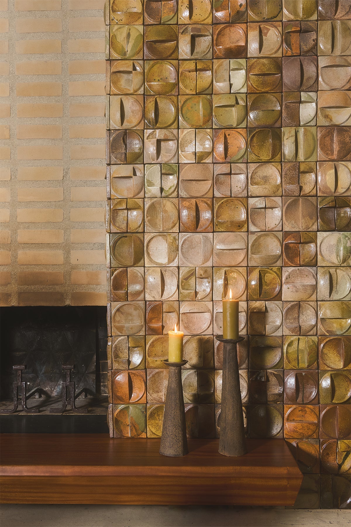 Indi stone pillar candle holders by Olsson & Jensen grouped by a tiled fireplace