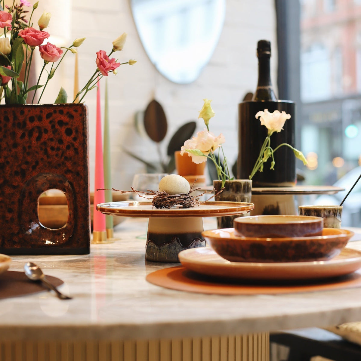 A glimpse of Nordic-inspired dining: a beautifully curated table featuring hand-crafted tableware in playful colors and clean lines. Discover the joy of everyday dining with northhome.xyz