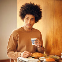 guy with a slight moustache drinking his morning coffee from a blue and white hkliving 70s collection mug 