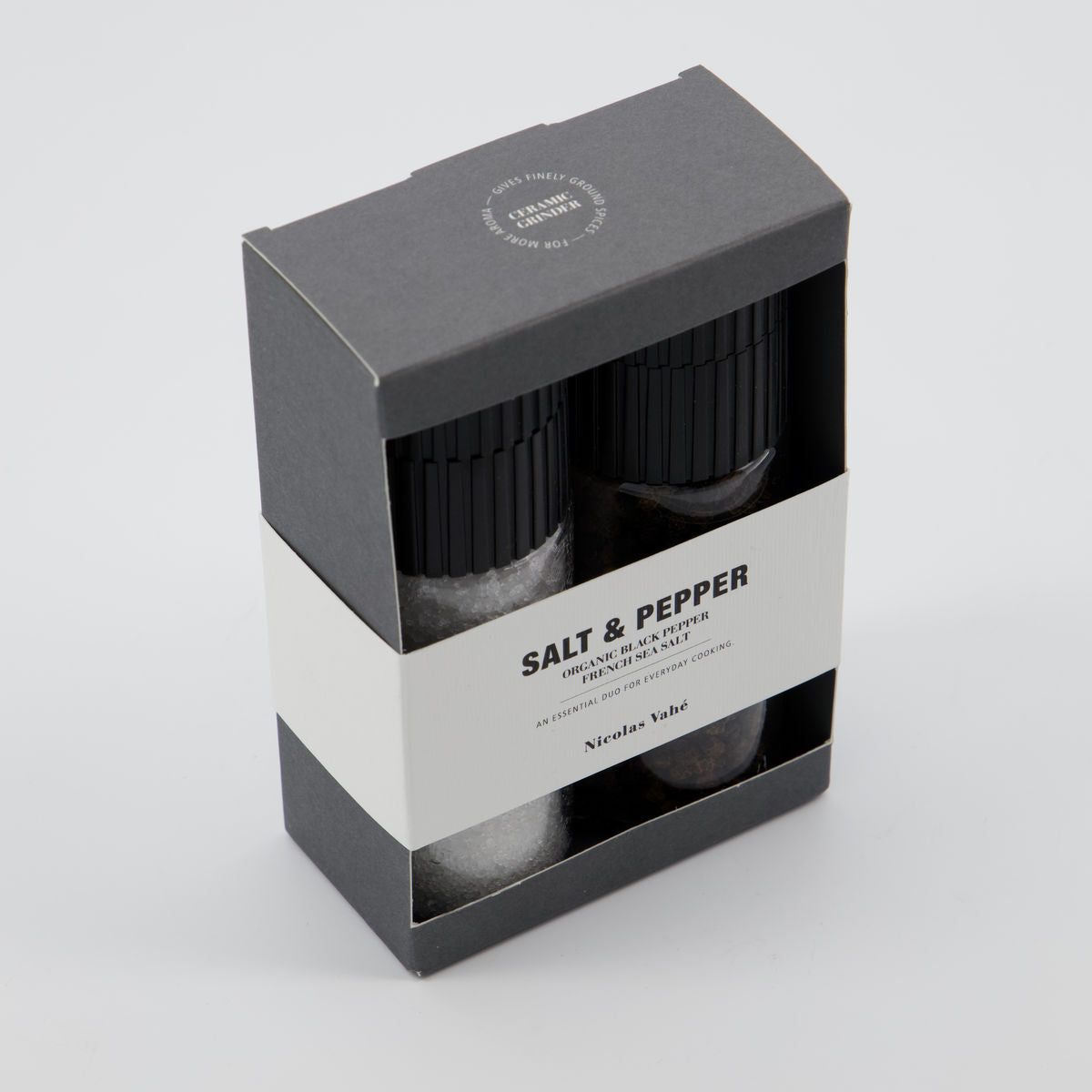 Salt and pepper shakers in a black and white packaging box on a light gray background