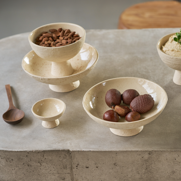 small lav footed bowl with snacks styled on a table with other pedestal bowls

