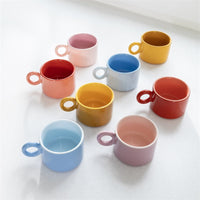 Two pink &klevering Chiquito mugs stacked on a counter in a soft-toned kitchen.