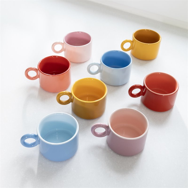 Two pink &klevering Chiquito mugs stacked on a counter in a soft-toned kitchen.