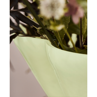 Close-up of the House Doctor Say vase rim with a wild bouquet of stems, leaves and seasonal blooms, soft lime glass adding a gentle pale chartreuse accent