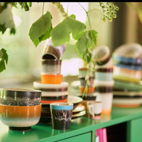 a number of items from hklivings 70s colelction range including the bowls cups mugs and plates in a cacophany of colours