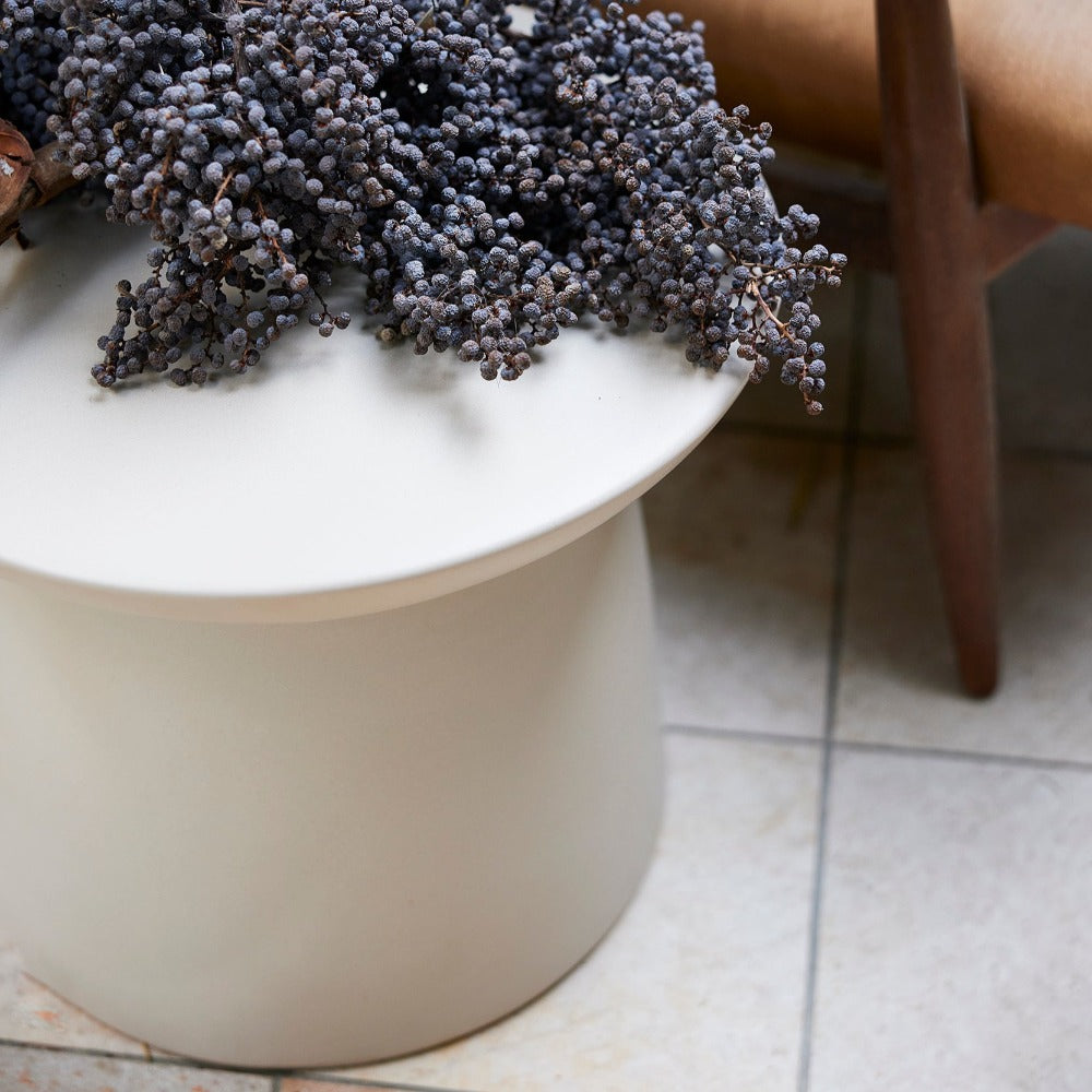 Cream HKLIVING earthenware side table topped with dried flowers on a tiled floor beside a wooden chair