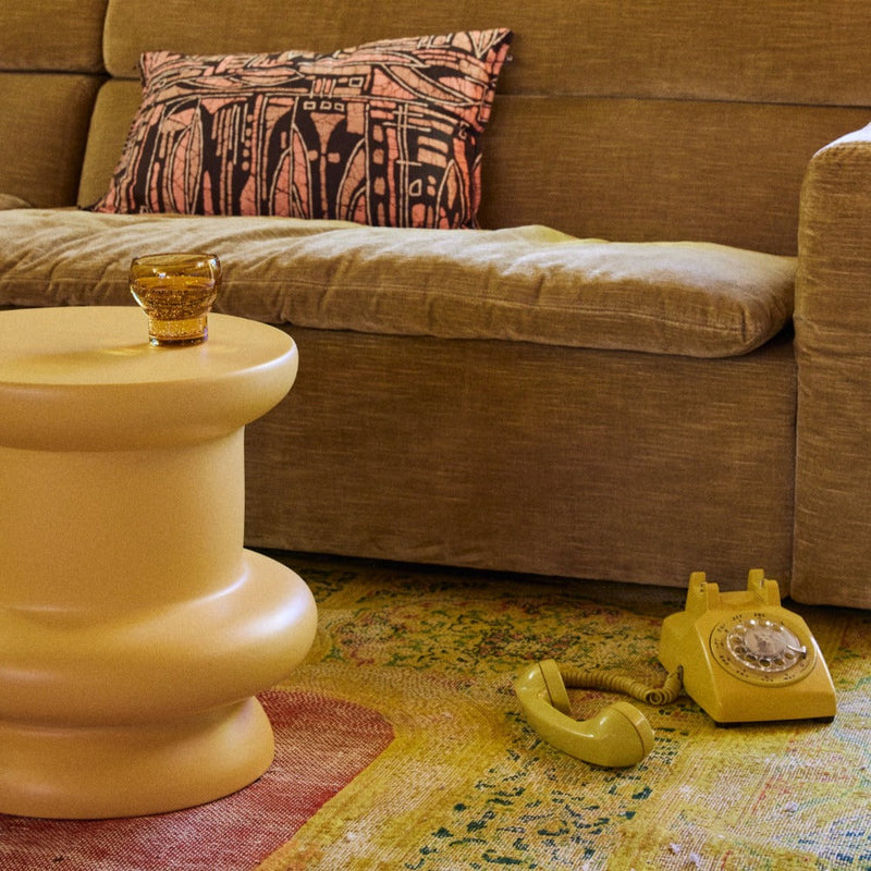 Sculptural honey side table next to sofa for contemporary decor
