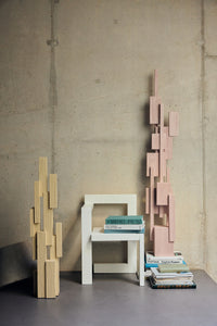 HKLIVING soft pink and cream Skyscraper sculptures styled together with a white chair and books against a concrete wall
