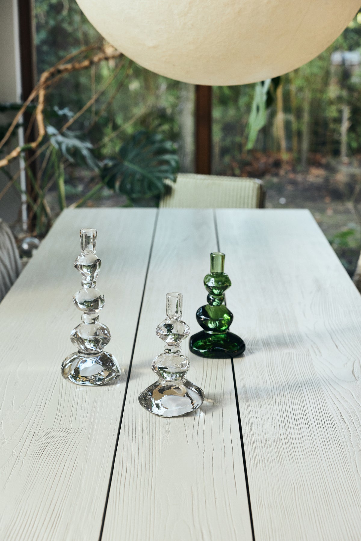 Nienke Sikkema glass candle holders in clear and green on a long white dining table