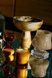 HKLIVING Marbled Bowl on Base in Ochre styled on a mirrored surface with glassware and a candle