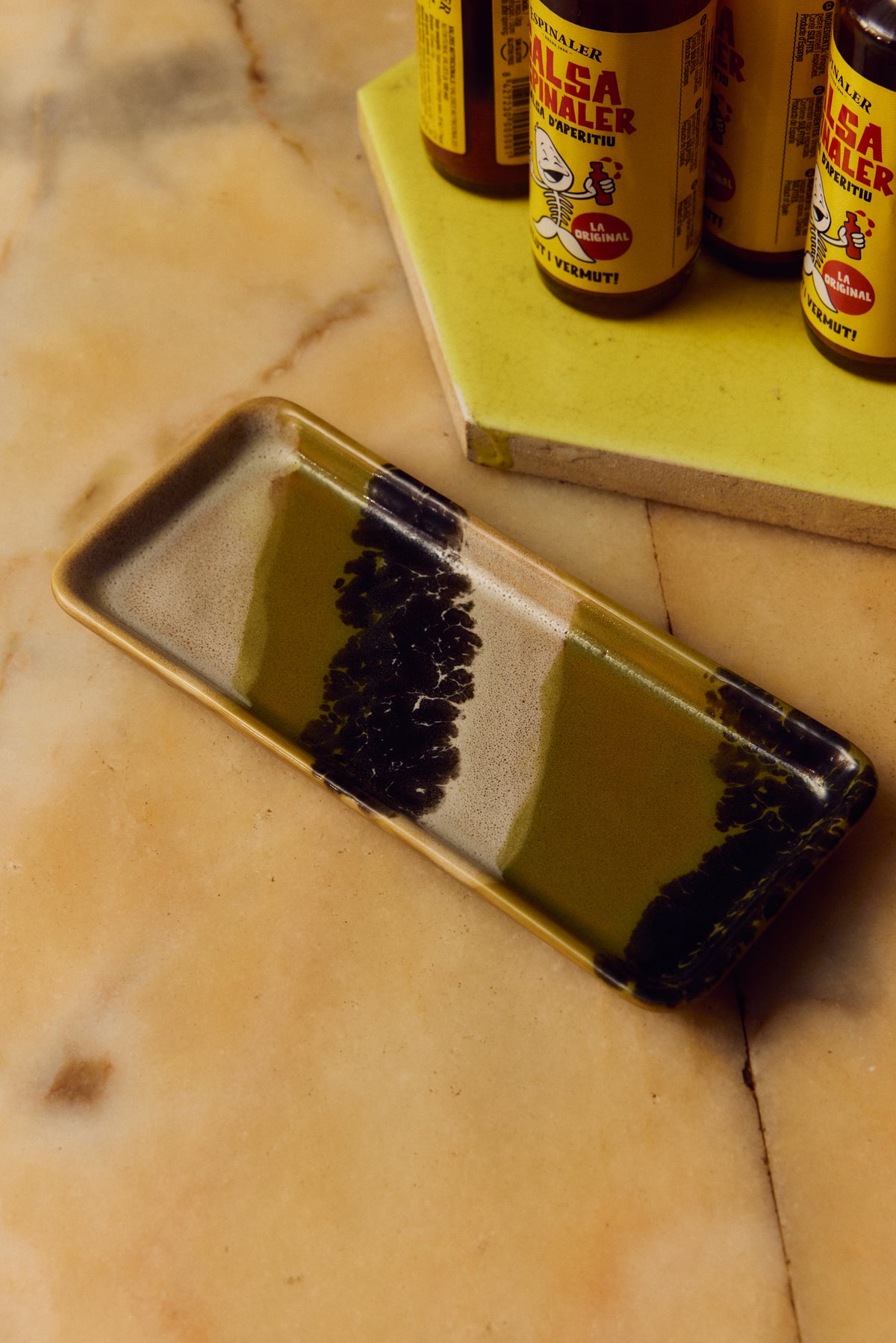 70s Ceramics Tray in Truffle by HKLIVING styled on a marble surface with vermouth bottles