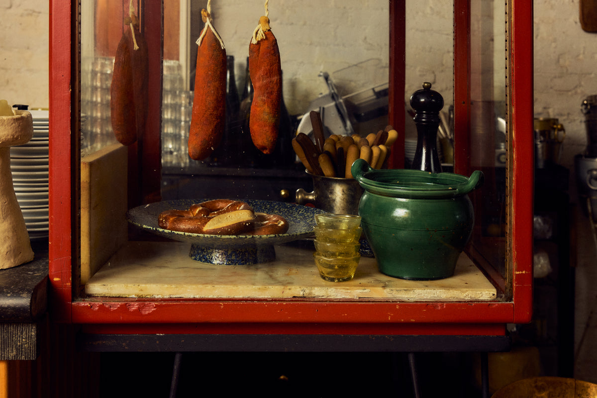 70s Ceramics Footed Fruit Bowl in Noise by HKLIVING holding a pretzel, displayed in a vintage red-framed deli cabinet