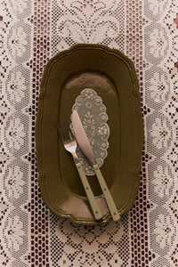 HKLIVING olive knife and fork resting on an olive scalloped plate over a lace tablecloth