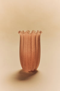 Ribbed glass vase in peach by HKLIVING styled on a warm beige background