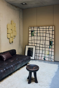 Wired framed canvas wall art by HKLIVING leaning against a concrete wall beside a leather sofa and framed portrait
