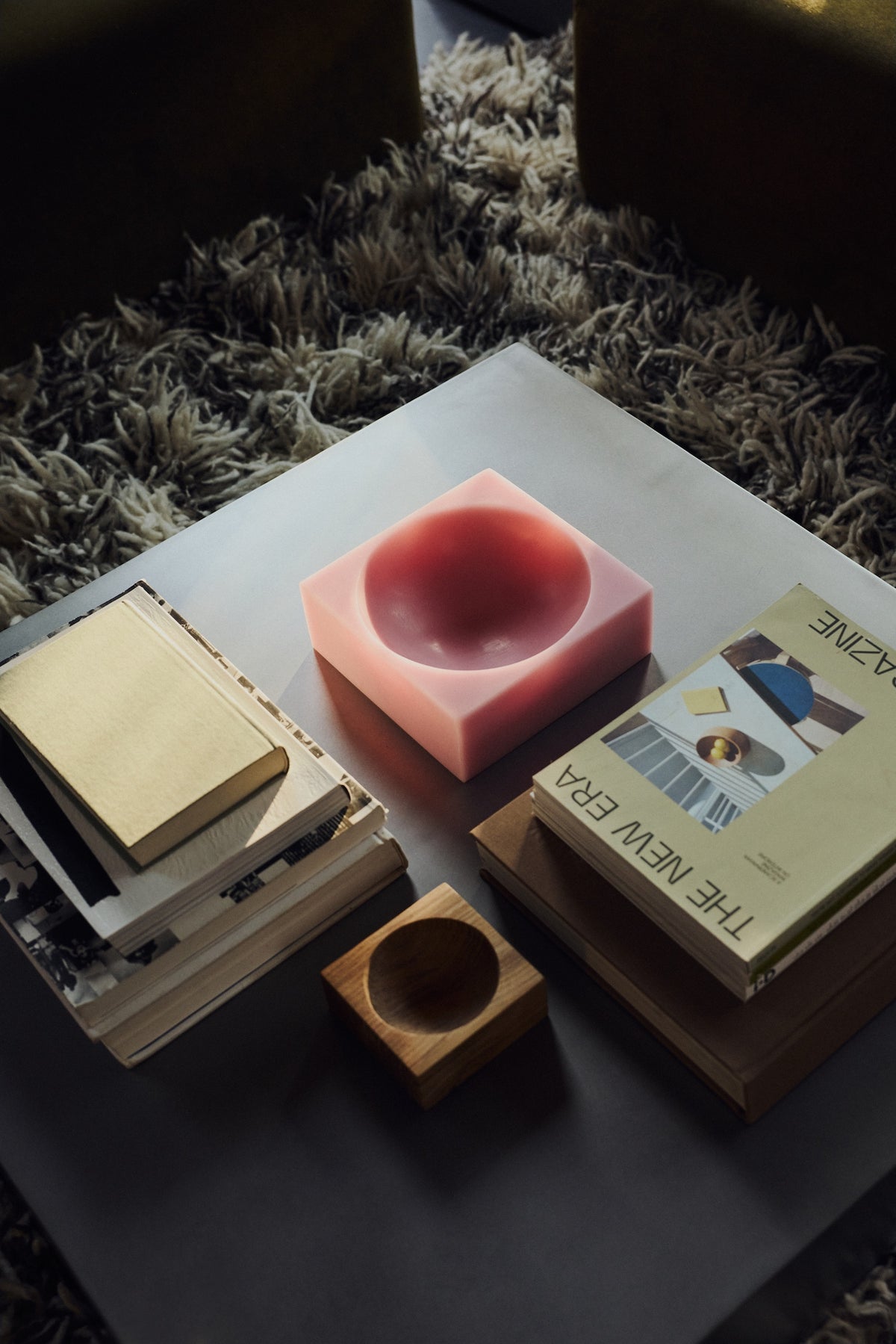 HKLIVING Pop Cube Large in Pink on a coffee table alongside stacked books and a magazine on a shag rug