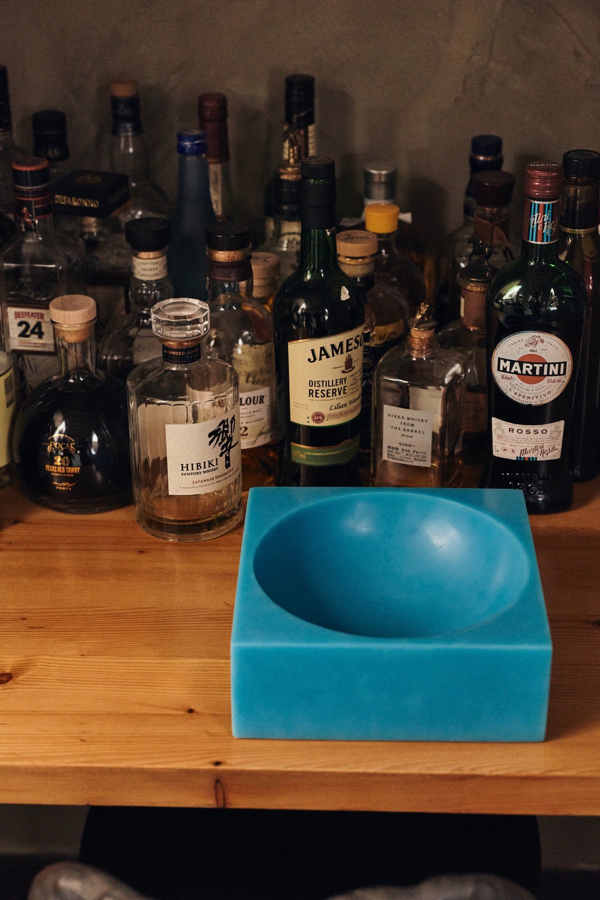 Close-up of HKLIVING Pop Cube Large in Blue on a timber shelf with spirits bottles in the background