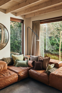 Leather sectional sofa styled with HKLIVING mint felt cushion alongside leopard print and linen cushions