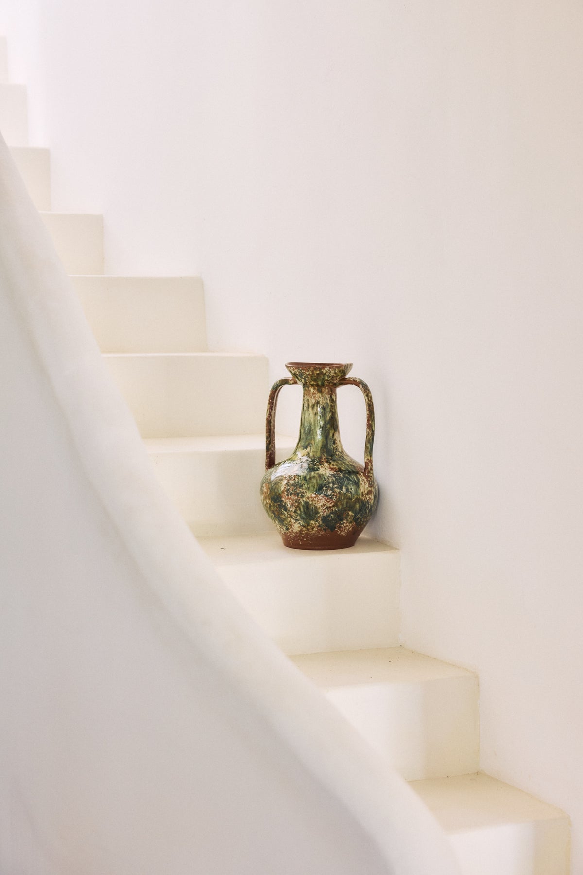 Robust Amphora Vase, Barn by HKLIVING displayed on a pale staircase, casting a soft shadow against the white wall