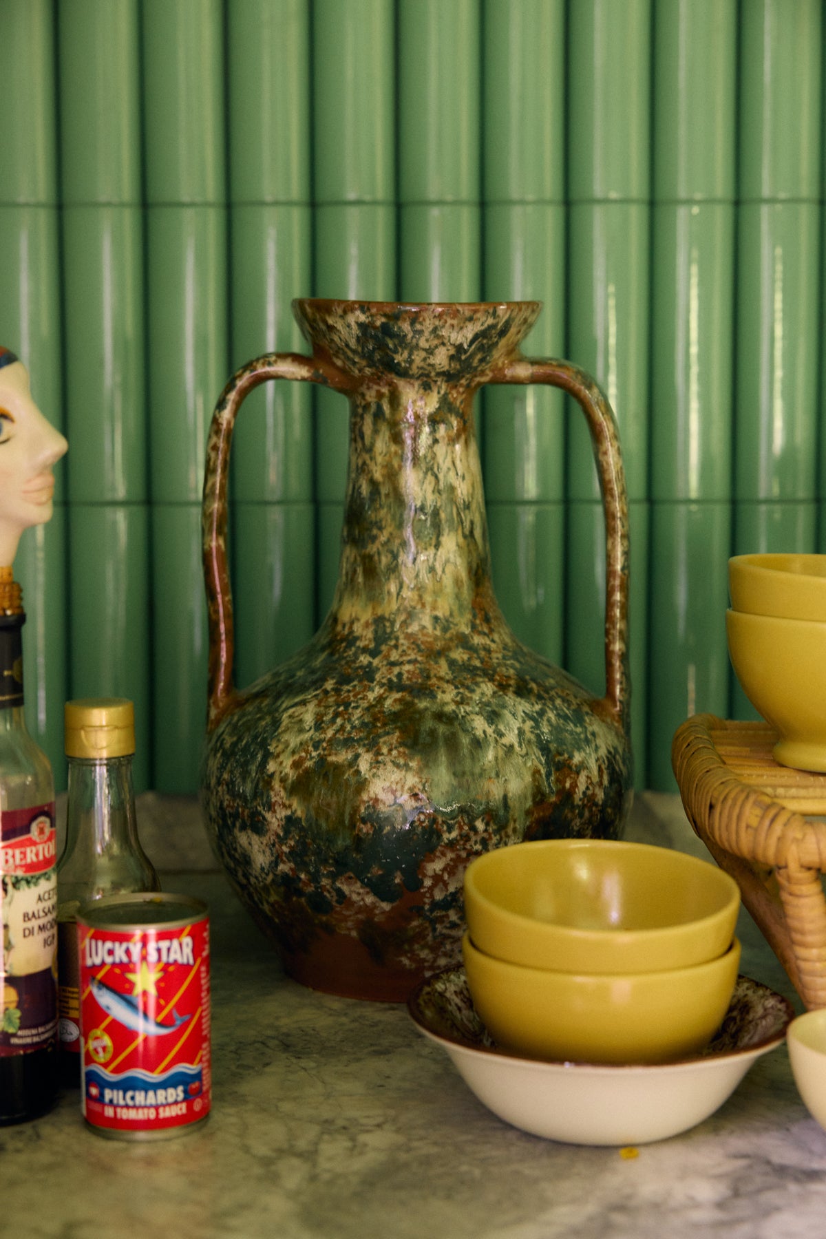 Robust Amphora Vase, Barn by HKLIVING styled on a kitchen counter in front of green tiles, alongside mustard-yellow bowls and pantry items