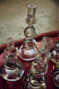 Nienke Sikkema glass candle holders catching the light on a red tray