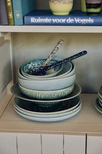 70s Ceramics serving spoons in Blues resting in a stack of bowls and plates on an open shelf