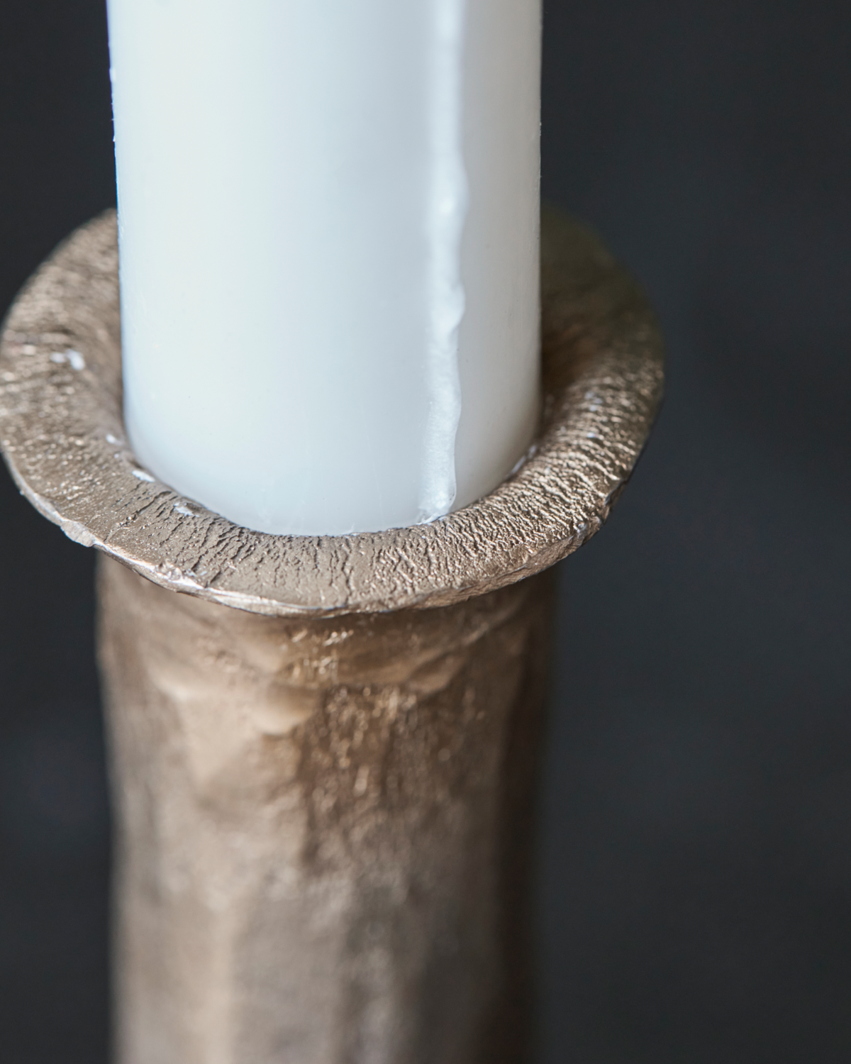 close-up of candle inserted into textured antique gold candle holder from House Doctor