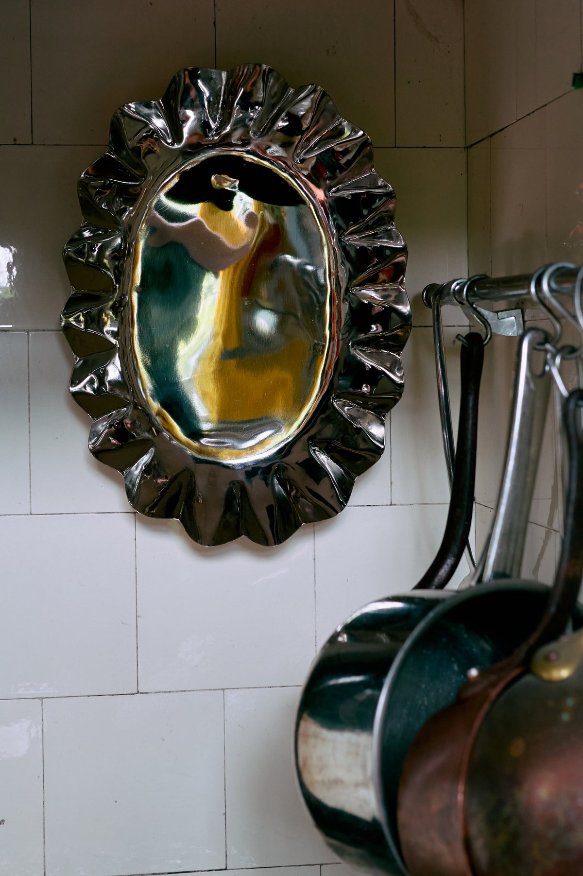 Close-up of the Medium HKLIVING chrome tray hung on a tiled kitchen wall, reflecting the room