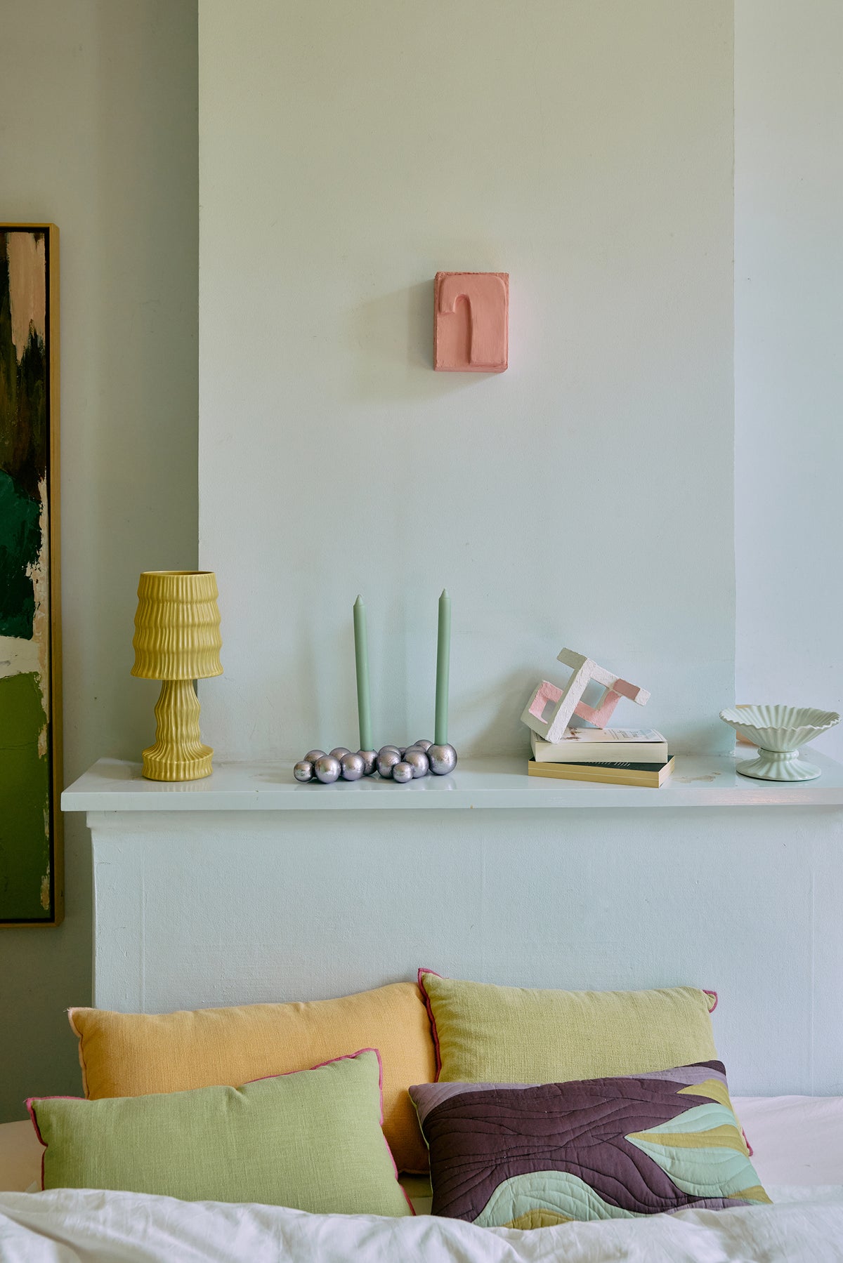 HKLIVING Pocket Exhibit 'Crave' in pink, hung above a mantelpiece styled with candles, books and a table lamp