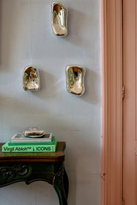 Three HKLIVING chrome glass wall sculptures mounted on a pale blue wall beside a pink painted door