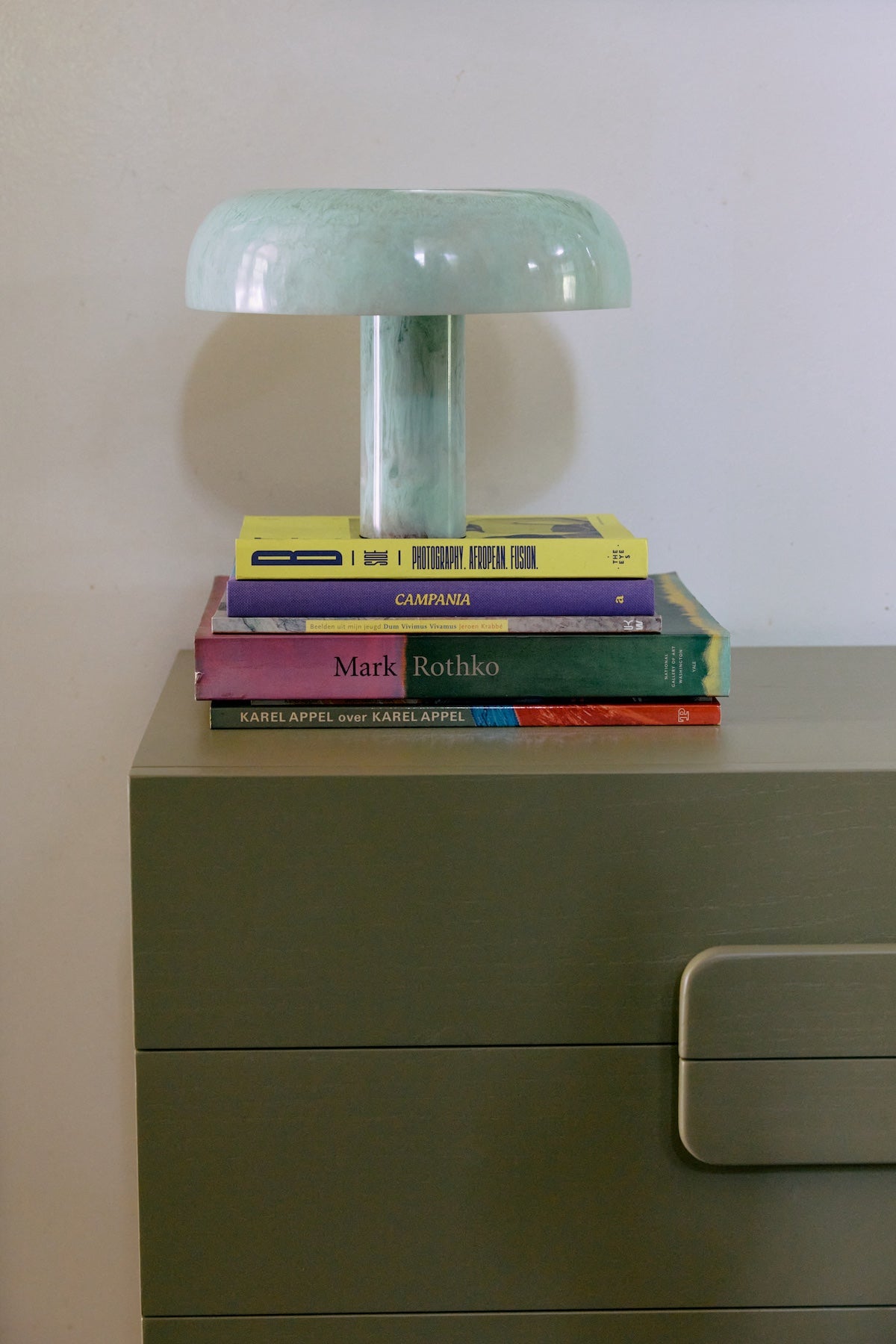 HKLIVING mint mushroom table lamp styled on a stack of art books on an olive green chest of drawers
