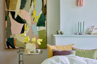 Room interior with abstract HKLIVING  painting, bed, and decorative items.