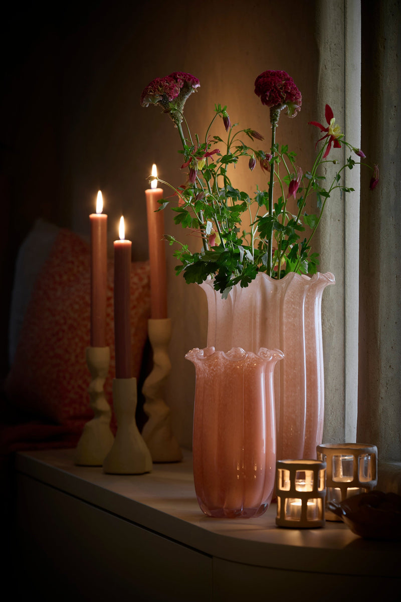 peach sedona glass vases styled with flowers and candles on a cosy evening shelf