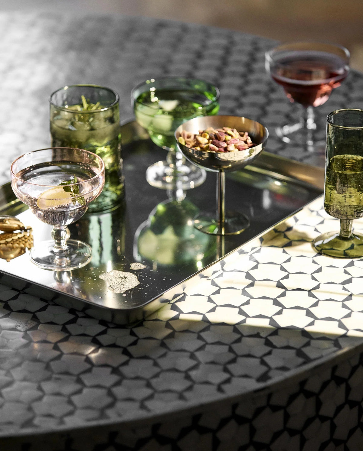 LUCIDUS chrome tray L by Nordal styled with cocktail glasses on a patterned table