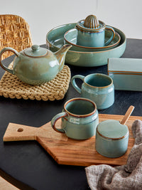 Pixie butter box green stoneware with brown rim, styled with matching Pixie mugs and tableware
