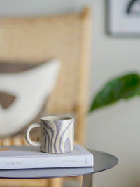 grey stoneware mug in scandi living room on book stack