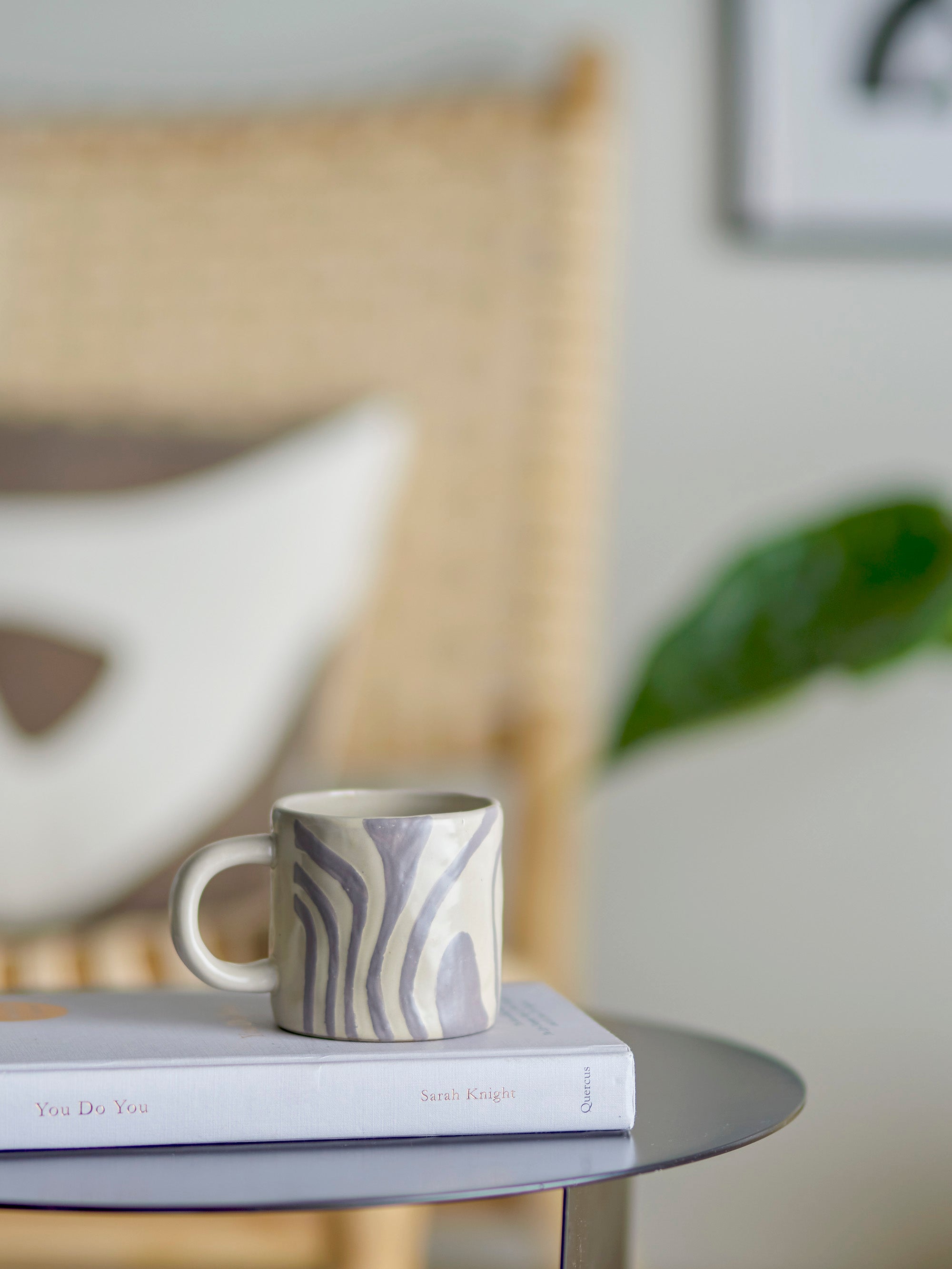 grey stoneware mug in scandi living room on book stack
