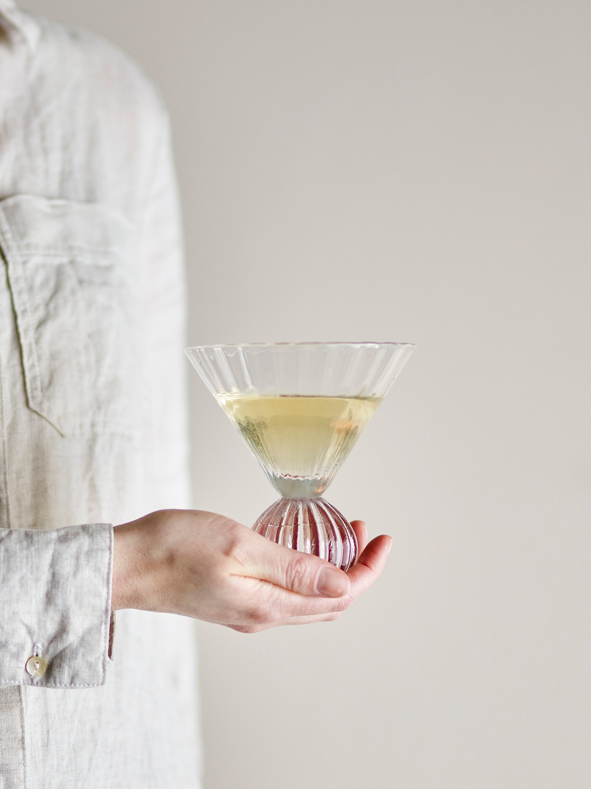 Taurin cocktail glass with round base, held in hand and filled with a cocktail, 300ml
