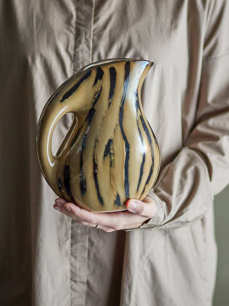 Coy Jug in brown reactive glaze stoneware, organic shape, held in hand
