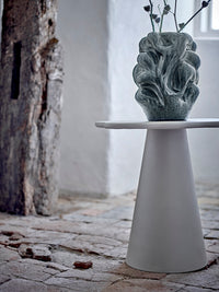 Vuelle grey vase with dried thistle stems on a white pedestal side table