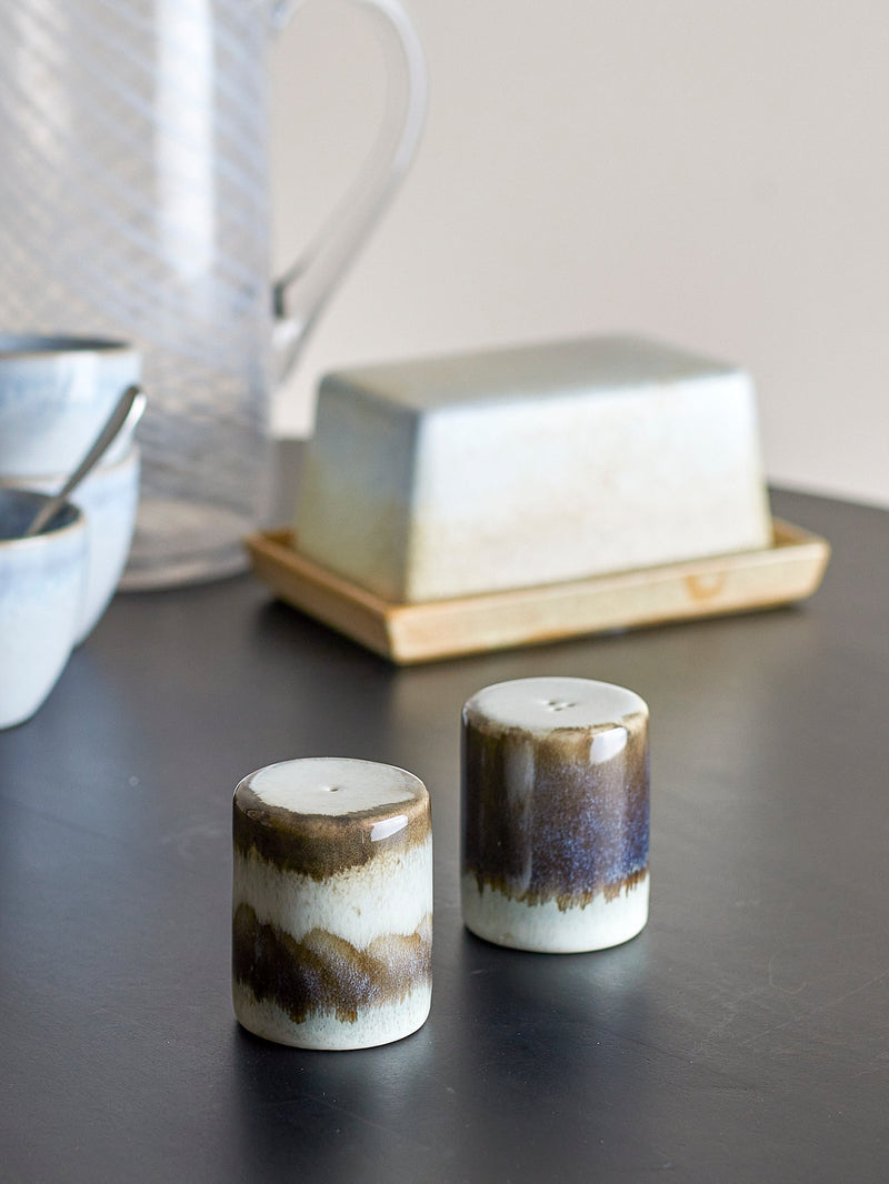close-up of grey reactive-glaze Paula salt and pepper shakers on a dark tabletop