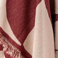 Close up of Olica throw fabric showing burgundy and cream abstract pattern detail
