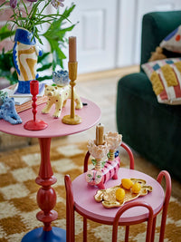 yellow bloomimgville eber candle holder styled on pink side table with colourful ceramics

