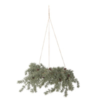 Cedar wreath hanging horizontally from three jute cords, with frosted green branches and pine cones, on a white background