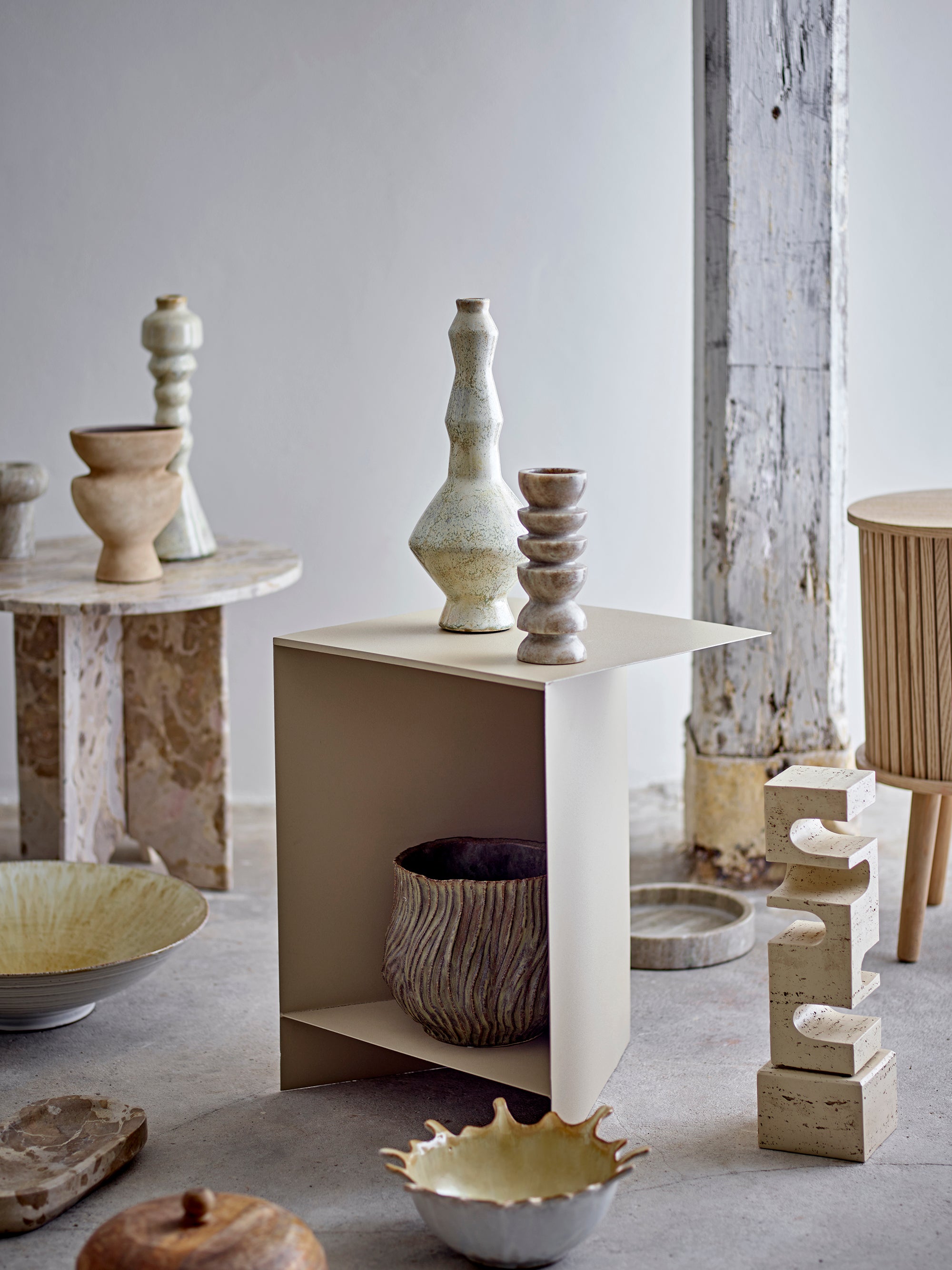 Collection of ceramic and stone sculptures on a neutral background