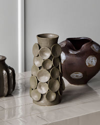 House Doctor Dot vase styled alongside the Expo vase and another stoneware piece, sculptural khaki and brown ceramics on a pale console for a layered shelf look