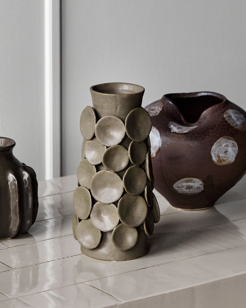 House Doctor Dot vase styled alongside the Expo vase and another stoneware piece, sculptural khaki and brown ceramics on a pale console for a layered shelf look