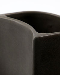 Close-up of the stepped shape and dark grey matte glaze on the Meraki Datura brush and soap holder