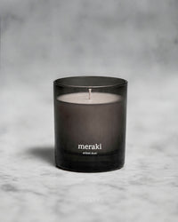 Meraki Amber Dust scented candle styled on a marble surface