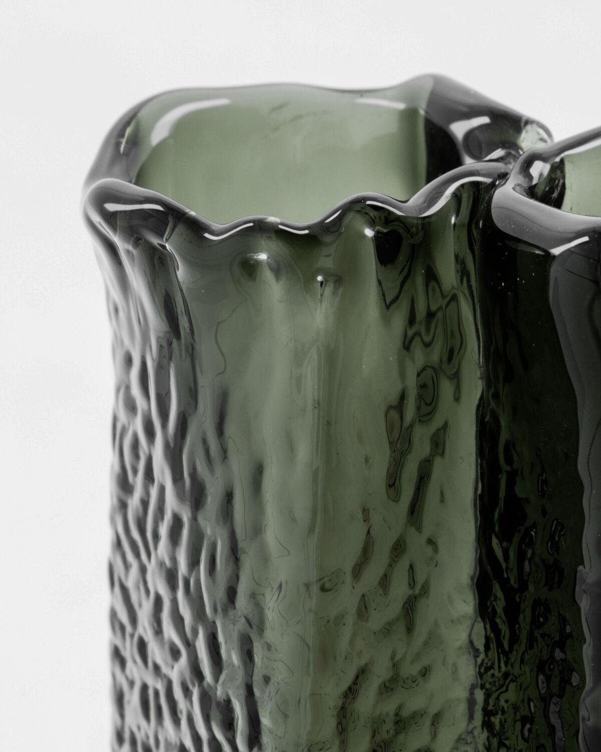 Close-up of the House Doctor Zuri vase's rim and ruffled glass texture in a rich, smoky Deep Forest green